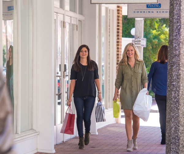 Two women carrying shopping bags walking together